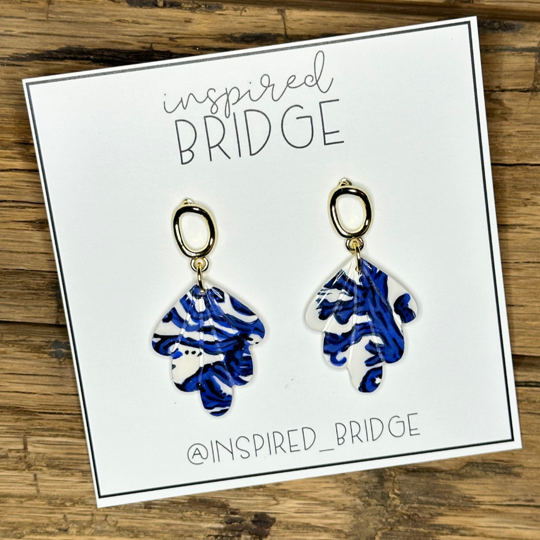 Hand-painted polymer clay dangle earrings made to match blue patterns dress.